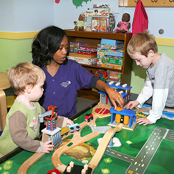 child care provider at activity table with children